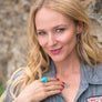 portrait of jewel wearing black gold druzy necklace and tundra ring from Songlines by Jewel handmade collection