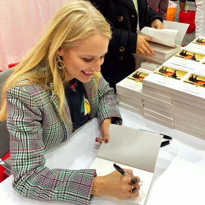 Jewel autographing her Never Broken books wearing Circle of Life earrings from Songlines by Jewel Handmade Collection