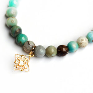  Blue jasper bead stretch bracelet with gold filigree star charm accented with a set polki diamond.