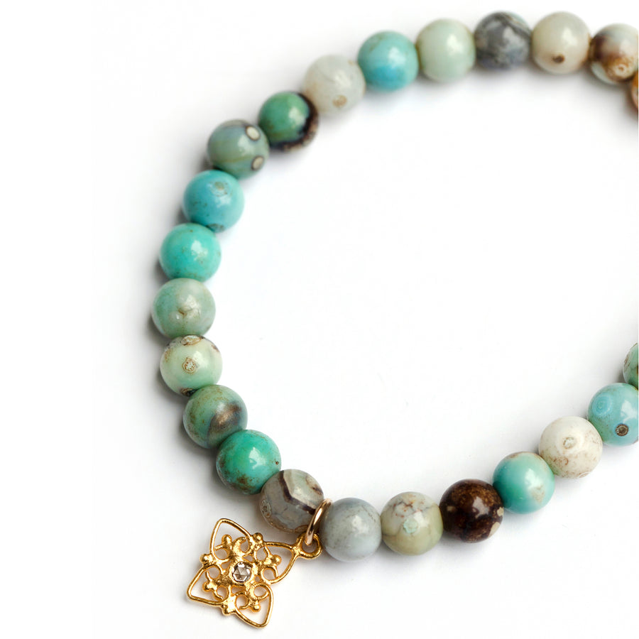  Blue jasper bead stretch bracelet with gold filigree star charm accented with a set polki diamond.